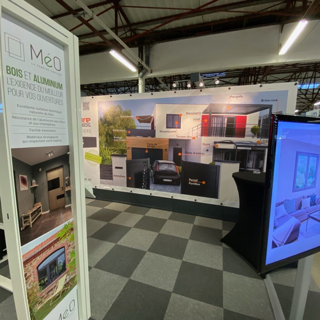 Visuel d'une bannière XXL pour un stand de MéO, présentant des produits en bois et aluminium pour des projets de construction et rénovation.