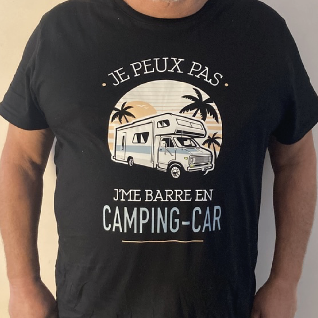 Visuel d'un t-shirt noir personnalisé avec une illustration d'un camping-car sous des palmiers et un coucher de soleil, accompagné du texte 'Je peux pas, je me barre en camping-car'.