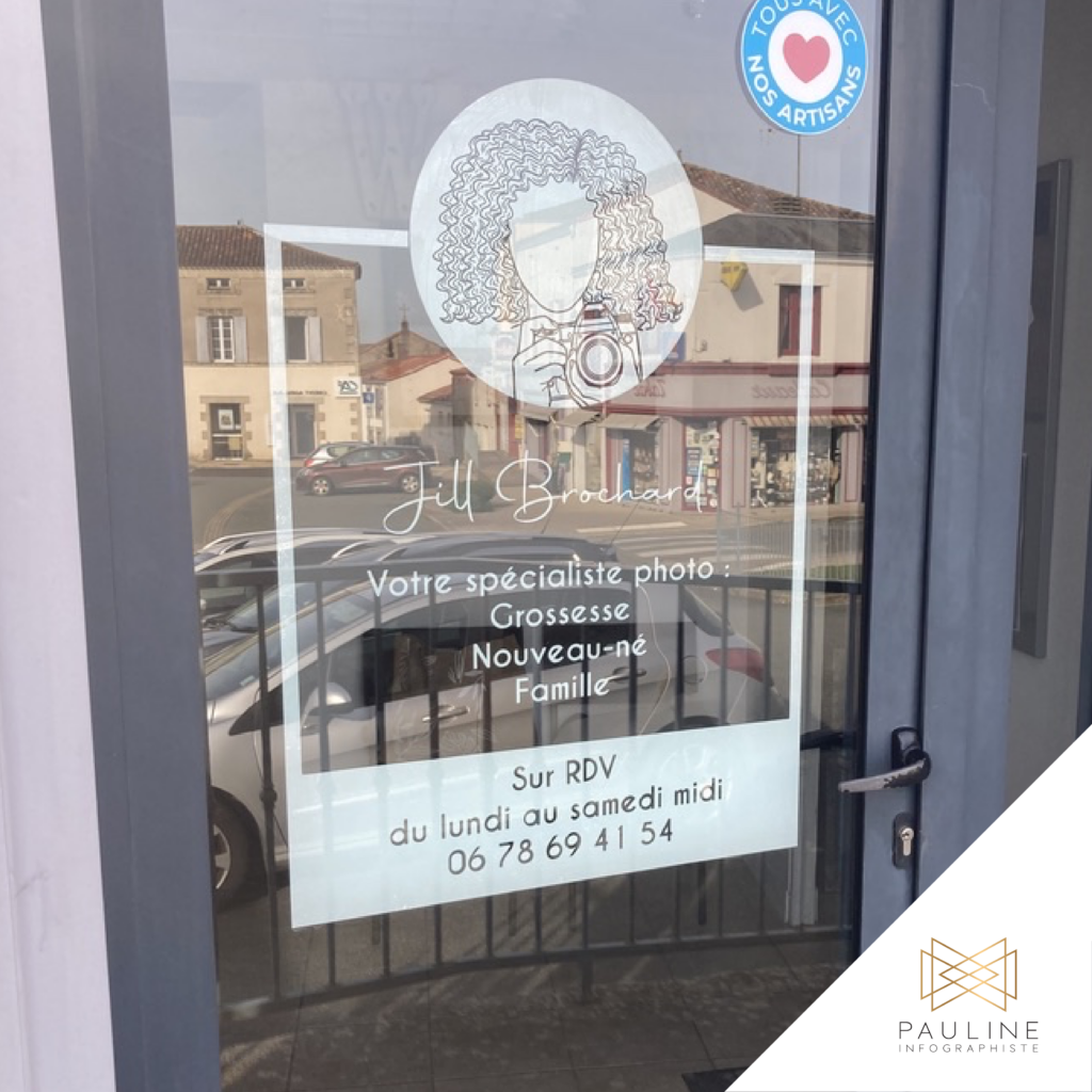 Visuel d'un autocollant pour vitrine posé à l'intérieur, pour Jill Brochard, photographe spécialisée dans les séances photo pour la grossesse, les nouveau-nés et la famille, incluant une illustration et des informations sur les rendez-vous disponibles du lundi au samedi midi.
