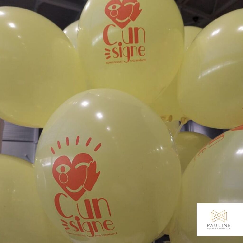 Ballons de couleur crème personnalisés avec le logo de 'C.un signe' et le slogan 'Communiquez avec sérénité', illustrant des goodies pour un événement ou une campagne de communication.