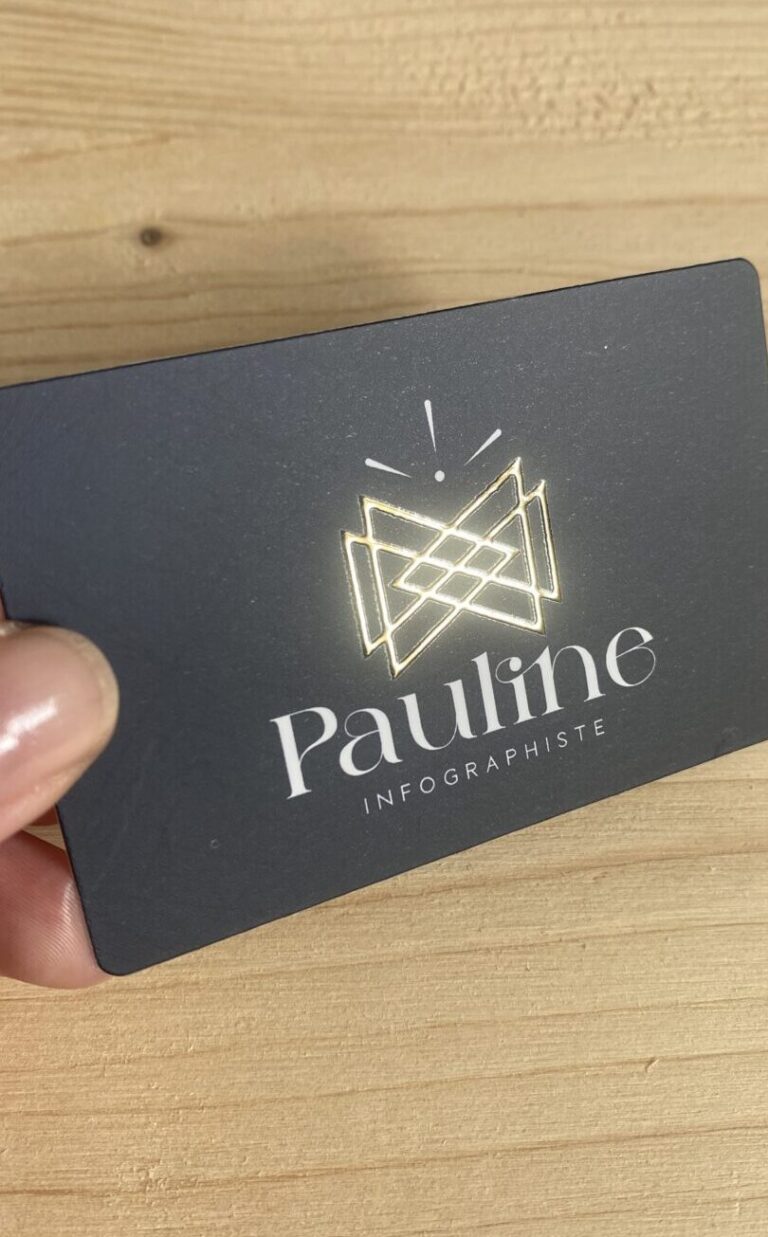 Carte de visite avec un pelliculage mat et un vernis sélectif doré, présentant le logo et le texte 'Pauline Infographiste' en lettres élégantes.